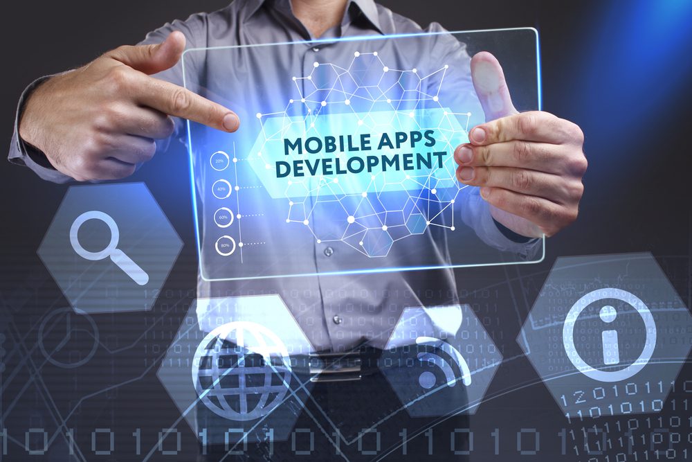 Business man holding holographic template labeled "mobile apps development"