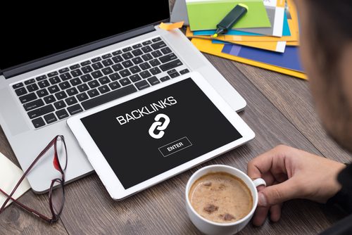 Laptop and tablet on table with "backlinks" shown on tablet screen