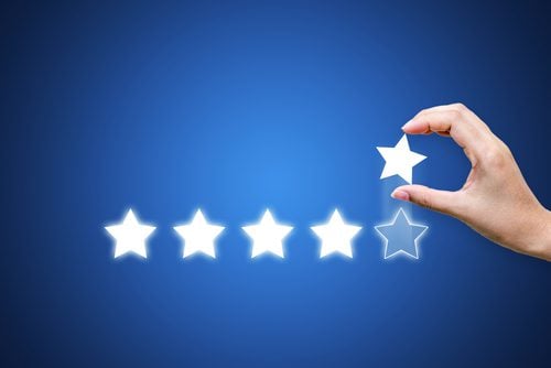 4-star review with hand placing a 5th star for a 5-star review.