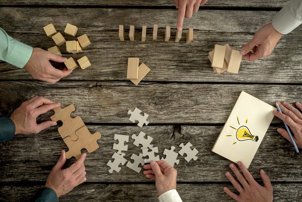 Puzzle pieces, dominos, and wooden blocks on wooden table