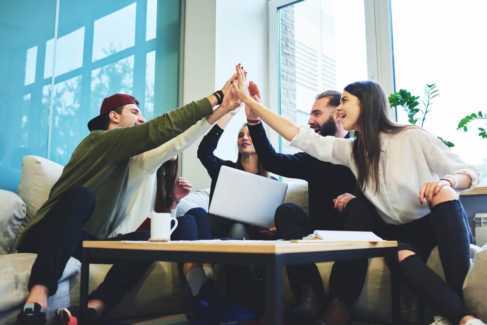 Marketing team celebrating with a group high-five