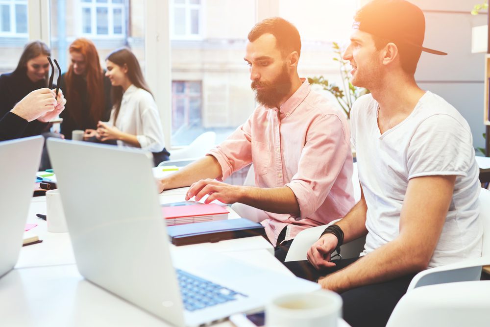 Marketing team researching influencers on laptops