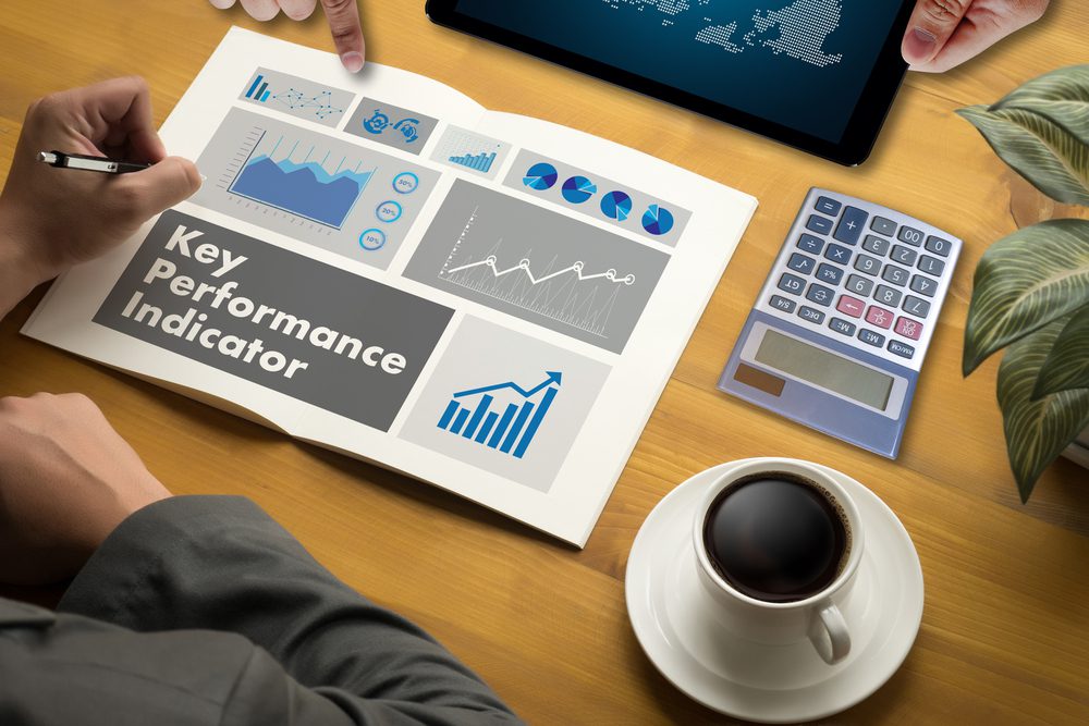 Tablet, graphs with KPIs mapped, next to a calculator on a conference table