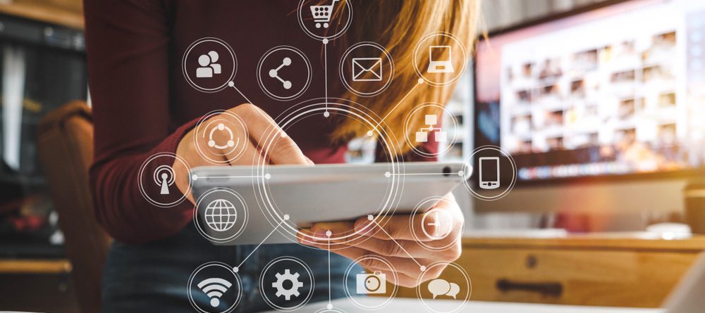 Woman holding tablet surrounded by various icons 