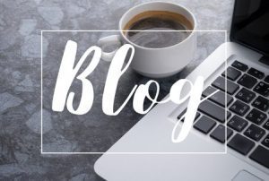 Cup of coffee next to a laptop and the word blog in the forefront