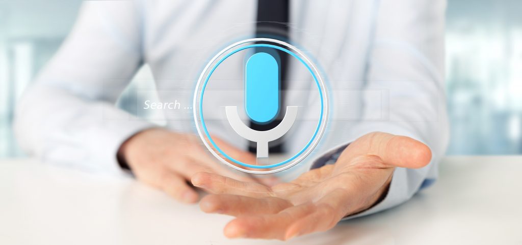 Healthcare professional with his palm facing app and a voice tech symbol hovering over his palm