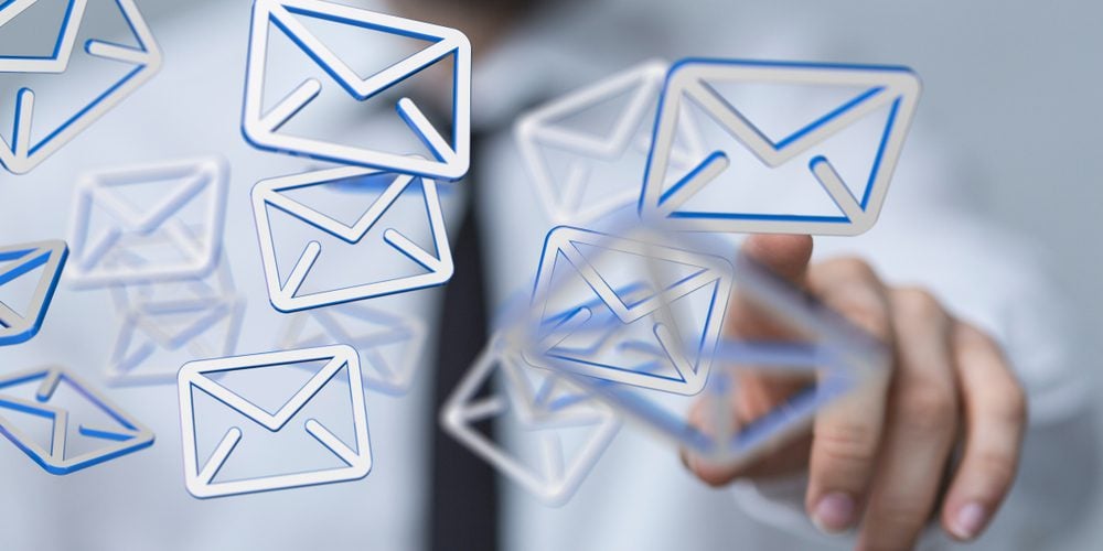 Man touching email icons floating in the air