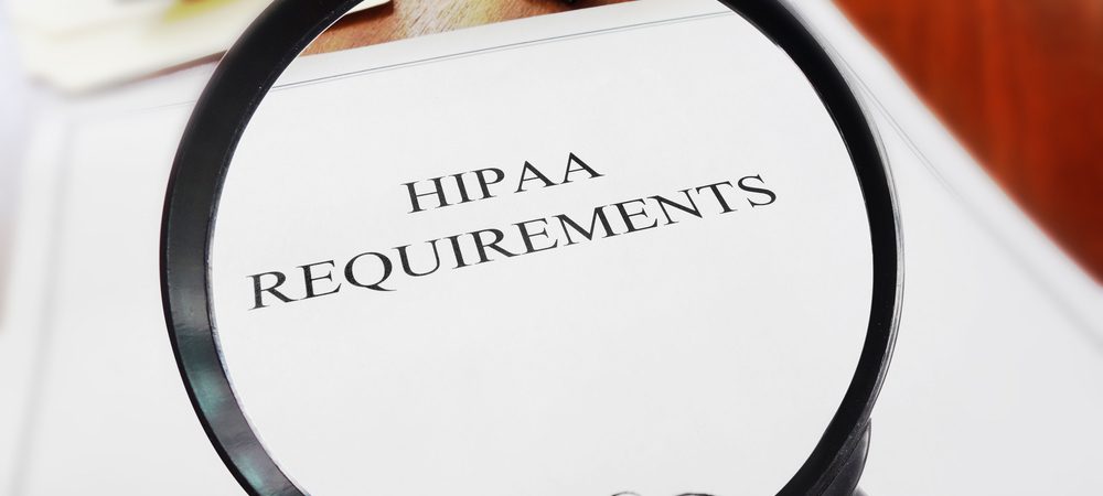 Magnifying glass hovering over a paper that reads Hipaa Requirements