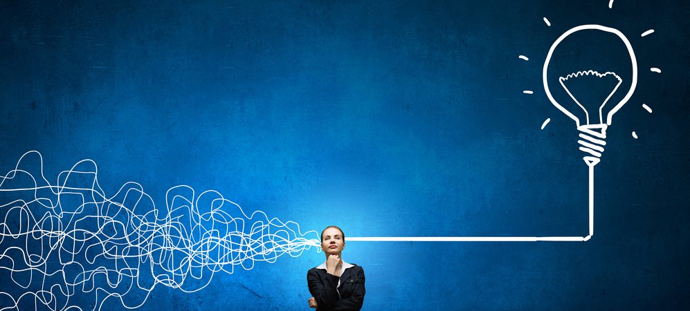 Woman thinking of a solution while connected to a giant light bulb