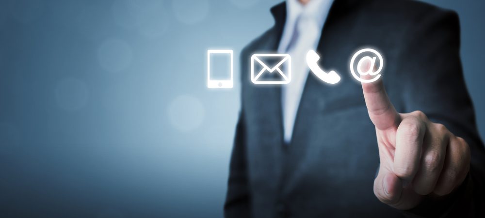 Business man touching the email symbol on a transparent monitor