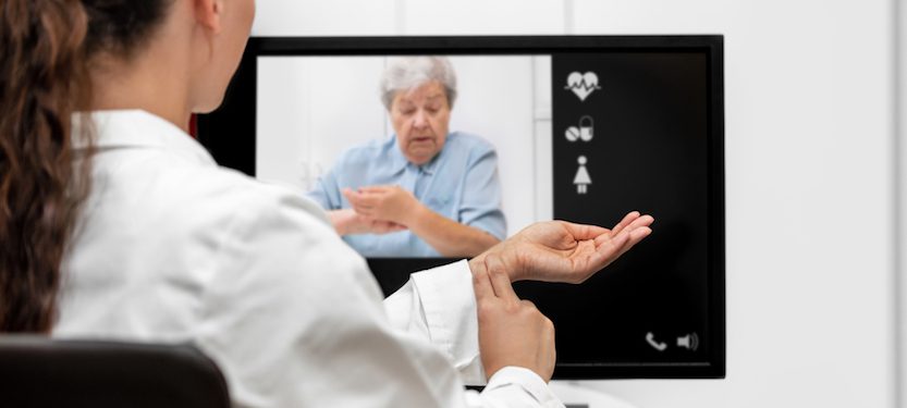 Doctor interacting with a patient via video display.