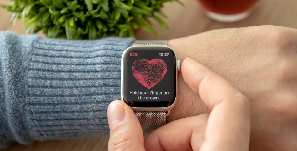 A person's wrist with a watch that displays their heartbeat