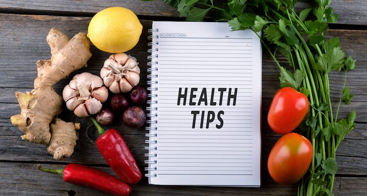 Paper journal with health tips on a table with fresh vegetables