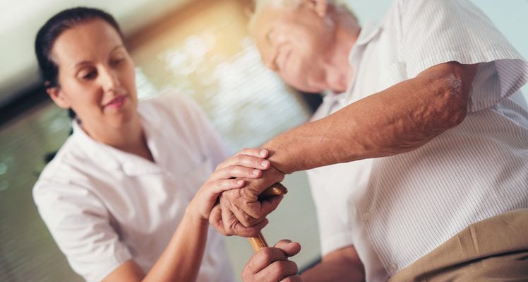 Female caregiver helping an elderly patient