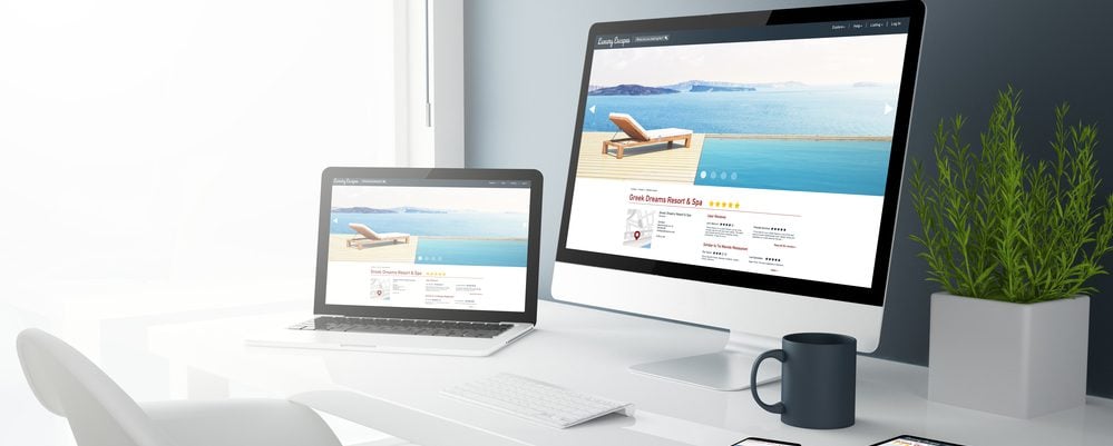 Computer and laptop displaying travel websites