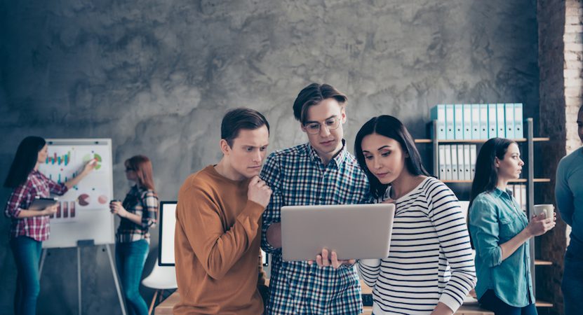 A group discussing strategy on a laptop.