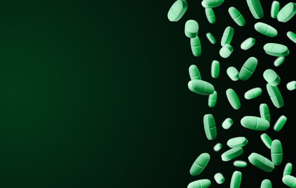 handful of green pills on a green background