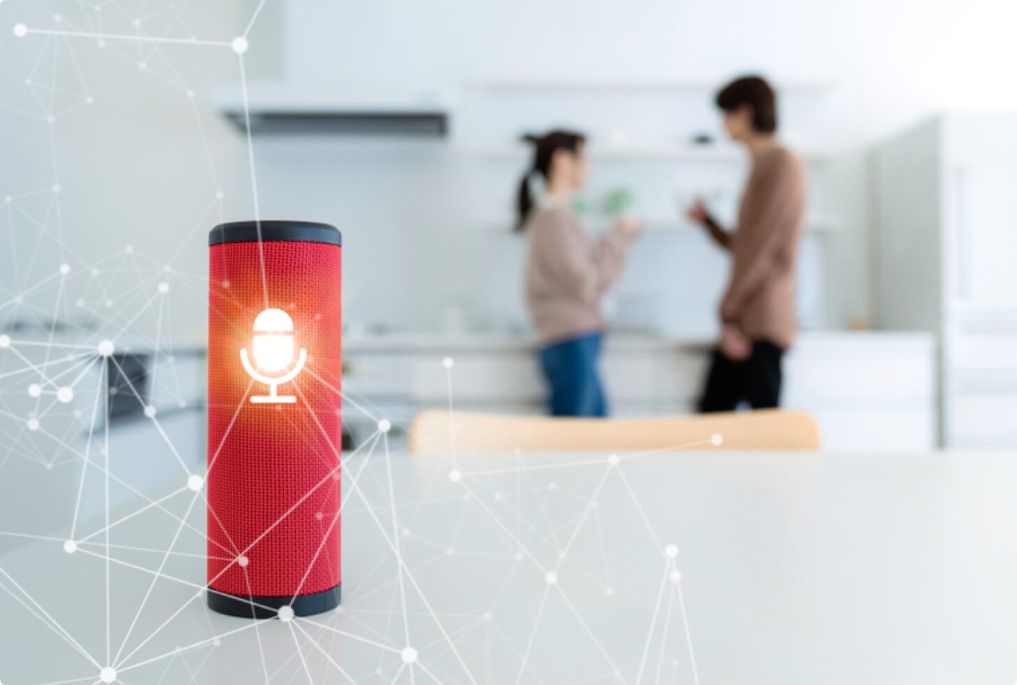 A red smart speaker shown in a kitchen with two people in the background