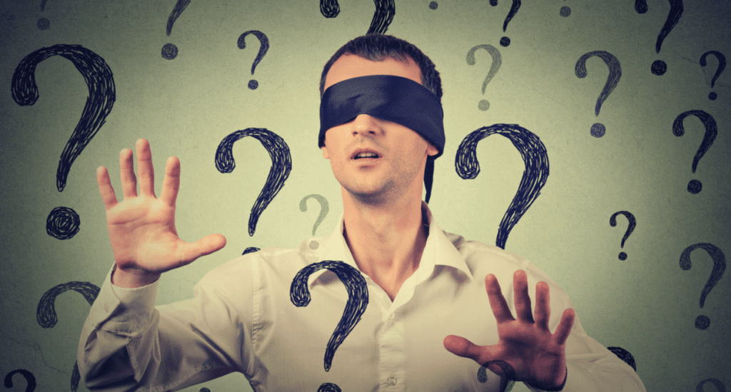 Blindfolded man surrounded by question marks.