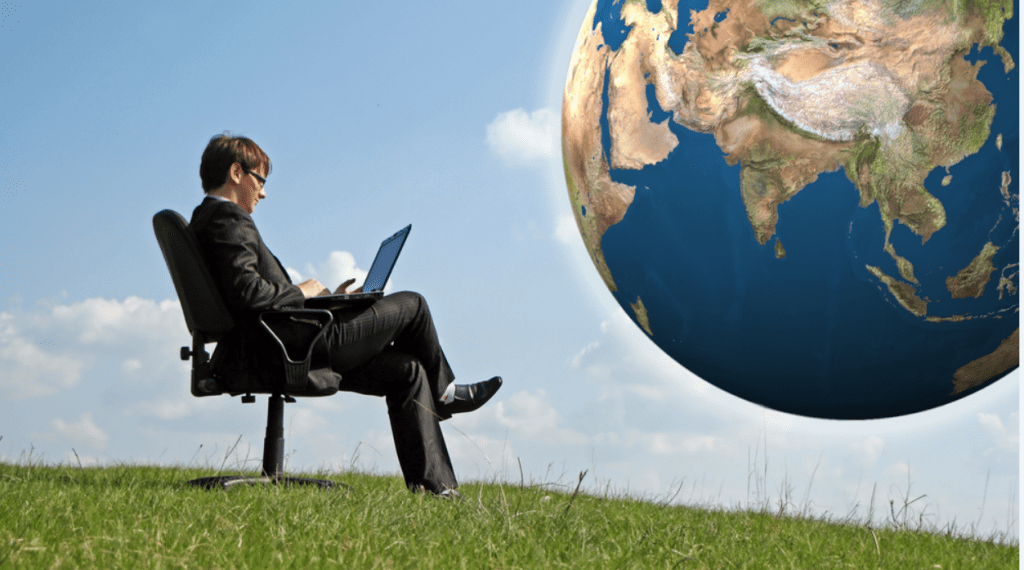 Person sitting outside with their laptop with a picture of the world in the distance.