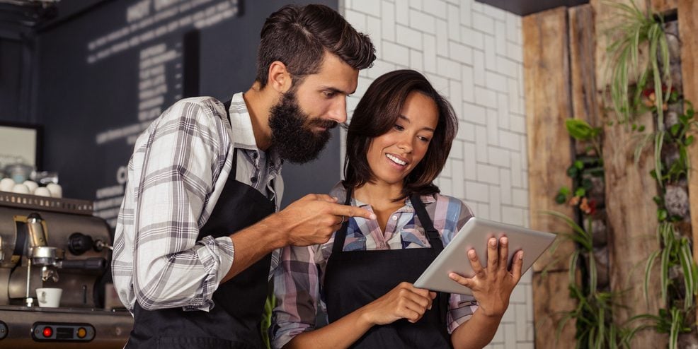 Two restaurant workers looking at a tablet