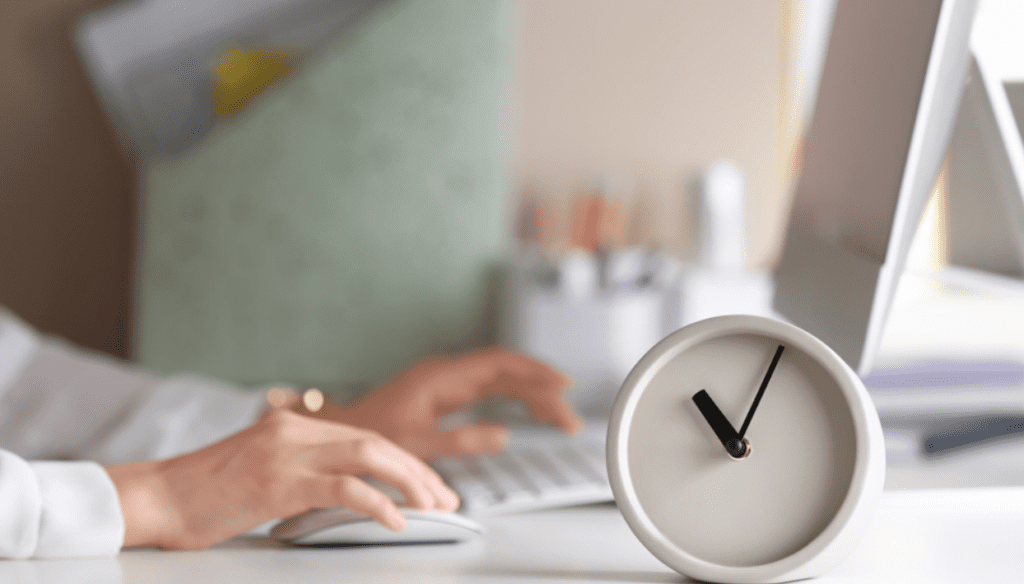 Person working at a computer while timing their work.