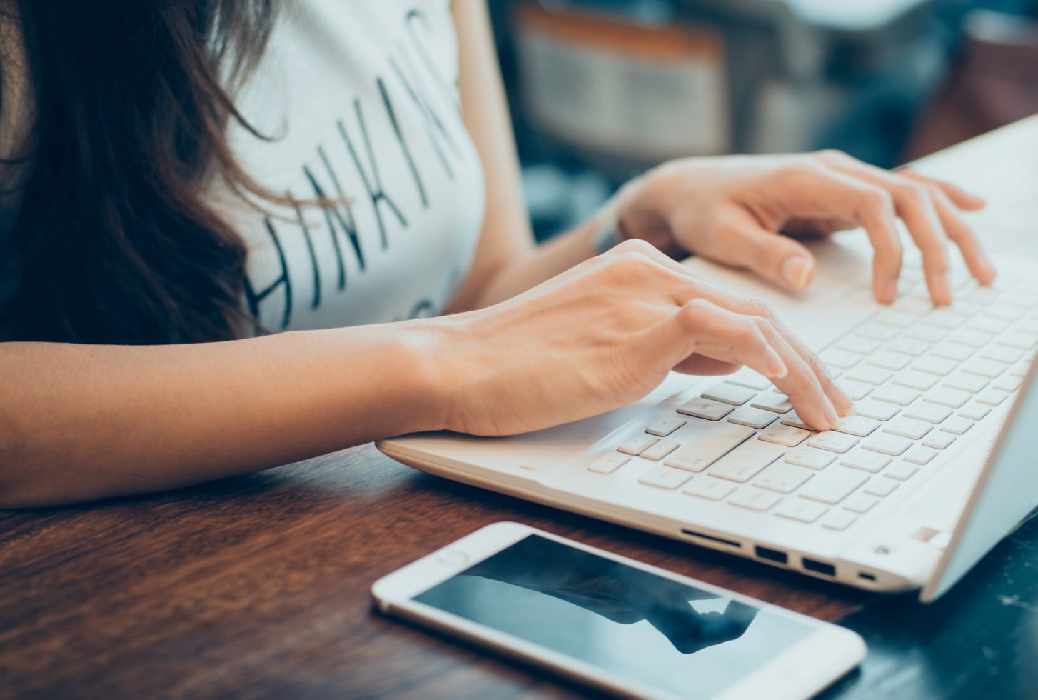 Picture of a woman's hands typing on a keyboard.