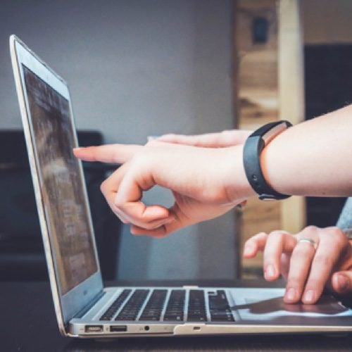 Hand pointing at a computer