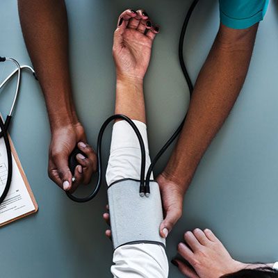 Nurse taking a person's blood pressure.