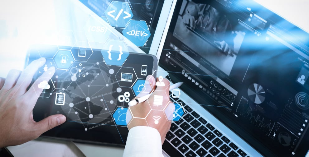 Man analyzing medical software on a laptop and a computer simultaneously 