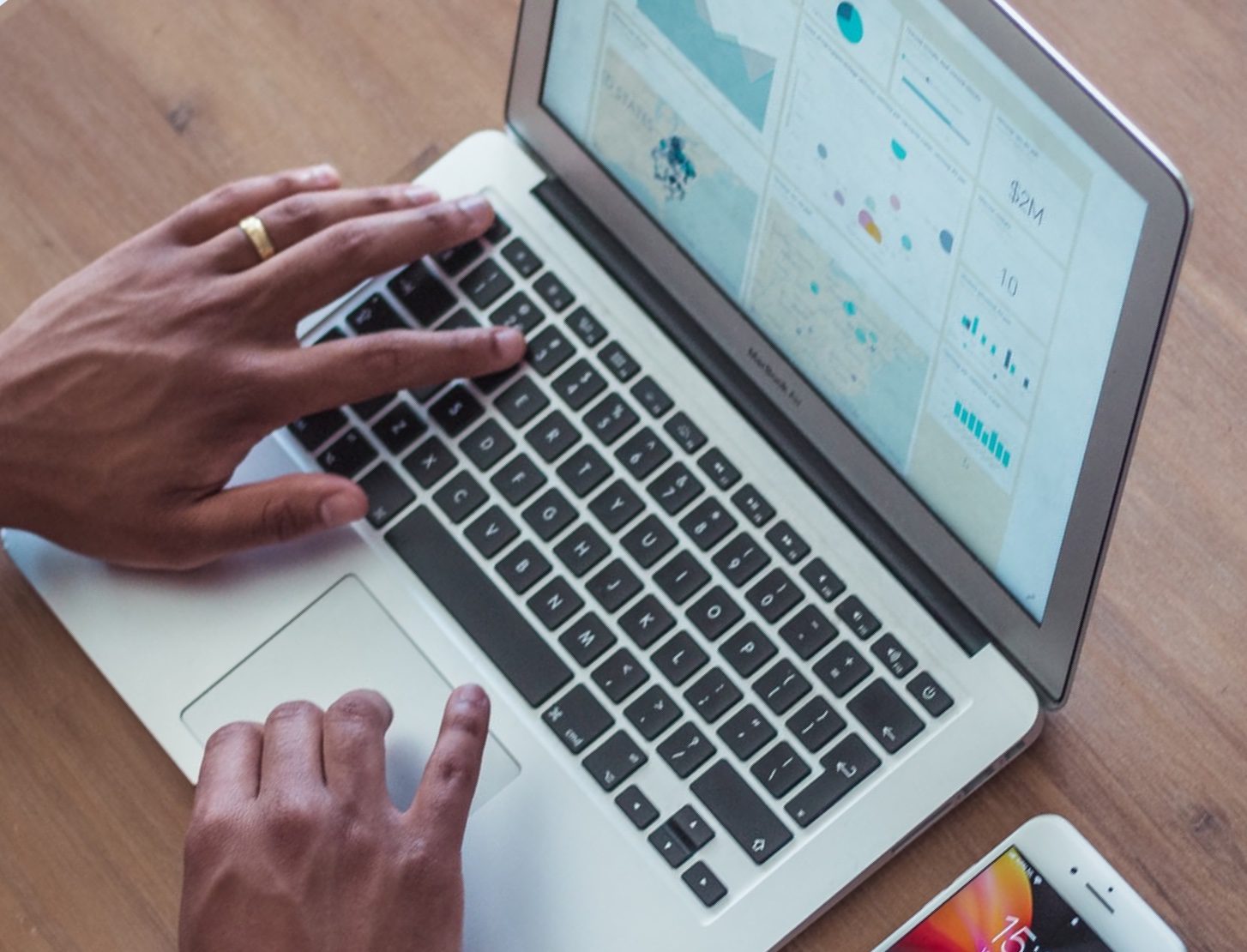 Hands typing on a laptop which shows an e-commerce website.