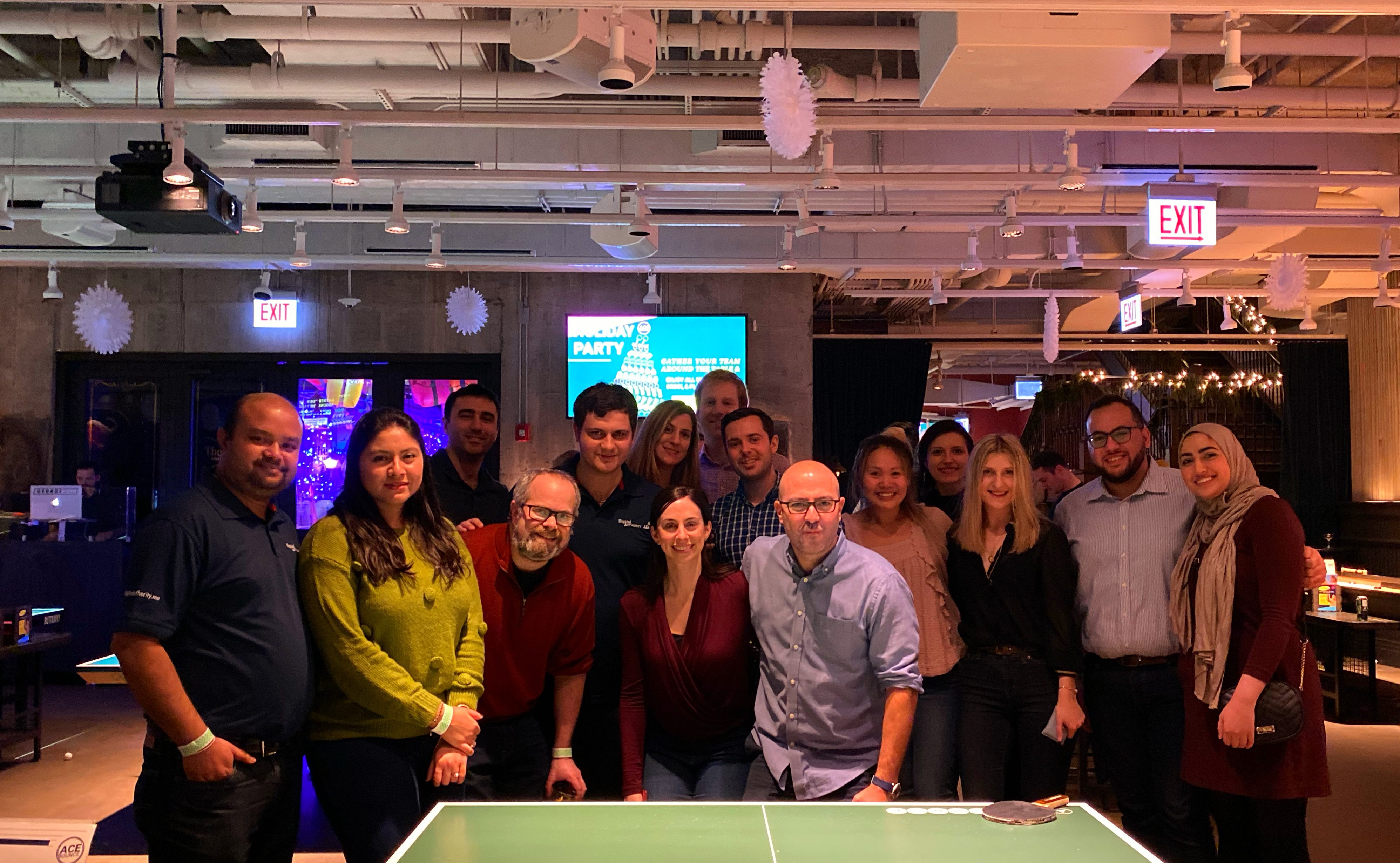 Digital Authority Partners employees and loved ones pose for group photo at annual holiday party.