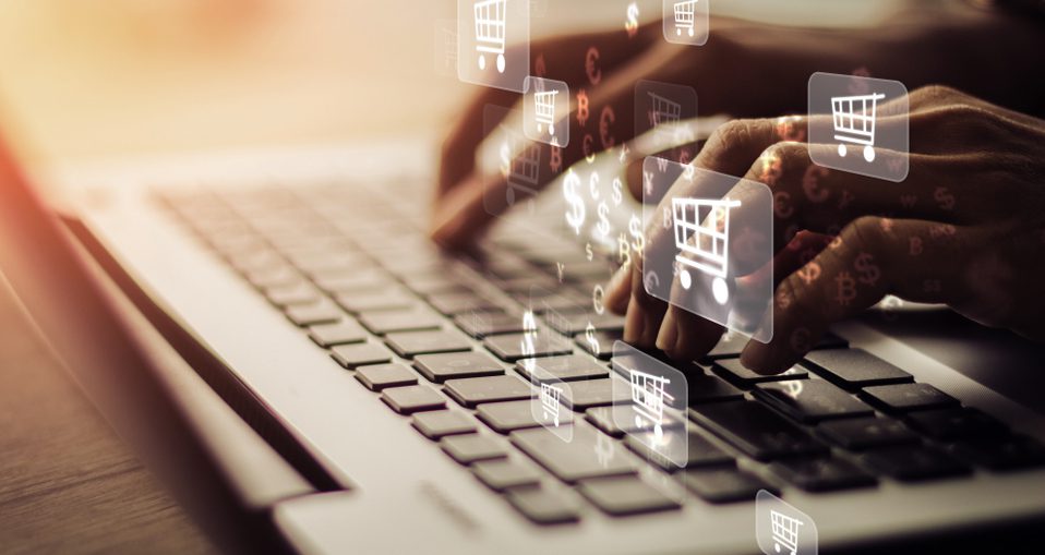 Hands typing on a computer, with e-commerce icons hovering over the keyboard