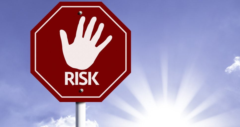 Red road sign displaying a hand and the word Risk
