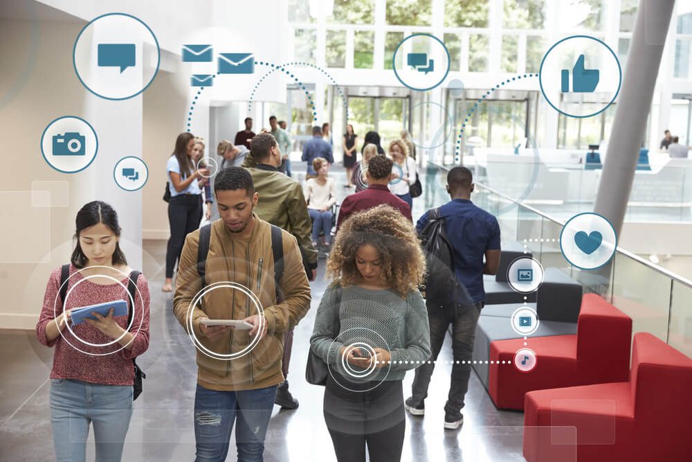 Students at a higher education school walk through a hallway on their mobile development apps