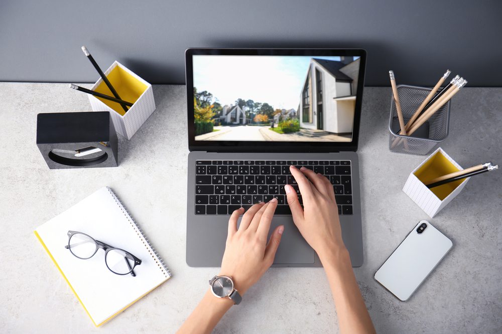 Businesswoman,Or,Real,Estate,Agent,Looking,Through,Online,Property,Portfolio