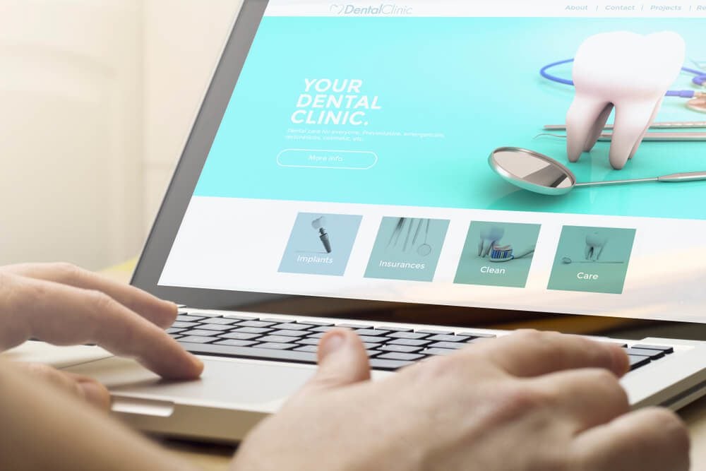 digital marketing for dentist_online business concept: man using a laptop with dental concept on the screen