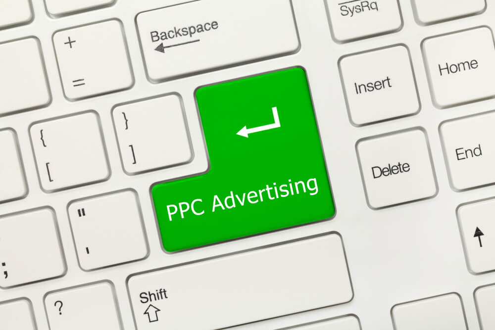 benefits of ppc_Close-up view on white conceptual keyboard - PPC Advertising (green key)