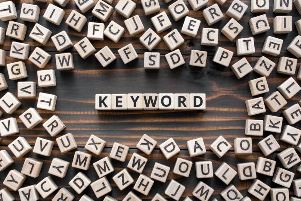 keywords_Keyword - word from wooden blocks with letters, search information that contains that word keyword concept, random letters around, top view on wooden background