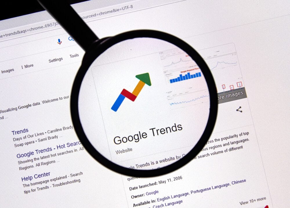 seo trends_Montreal, Canada - July 14, 2019: Google Trends web site under magnifying glass. Google LLC is an American multinational technology company that specializes in Internet-related services and products