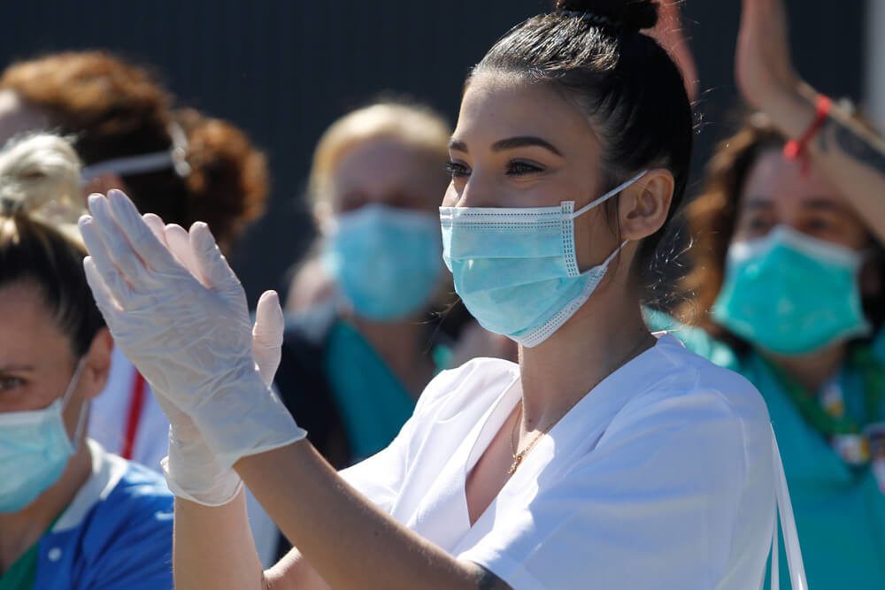 local healthcare_A Coruna-Spain.Healthcare workers dealing with the new coronavirus crisis applaud in return as they are cheered on by Civil Guard and other security forces outside the Hospital on March 26,2020