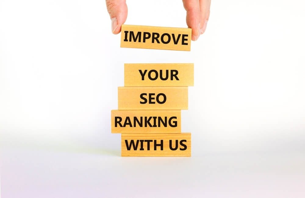 seo ranking_Improve your SEO ranking with us symbol. Wooden blocks with words Improve your SEO ranking with us. Businessman icon. Beautiful white background, copy space. Business, improve SEO ranking concept