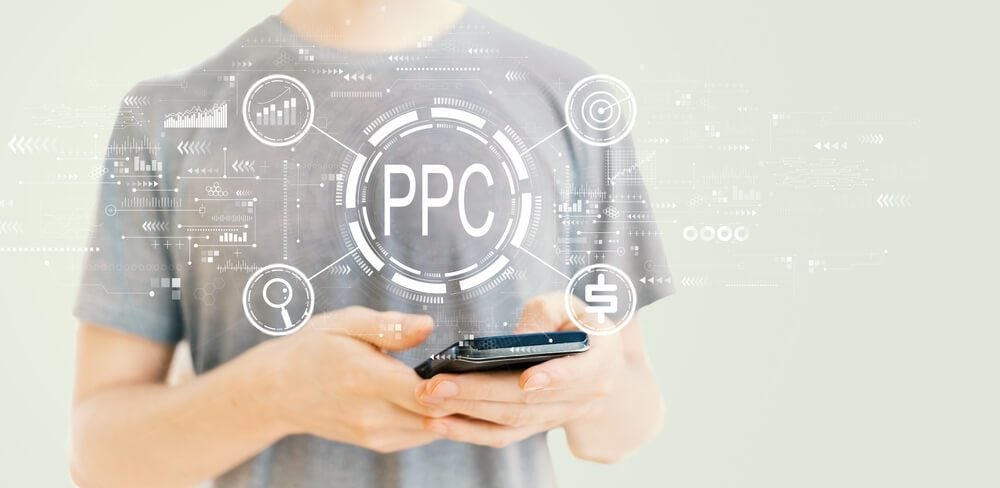 ppc business_PPC - Pay per click concept with young man using a smartphone