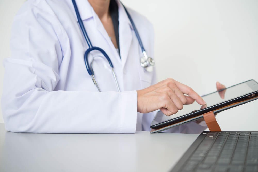 seo for doctors_hands doctor of a young girl working on laptop