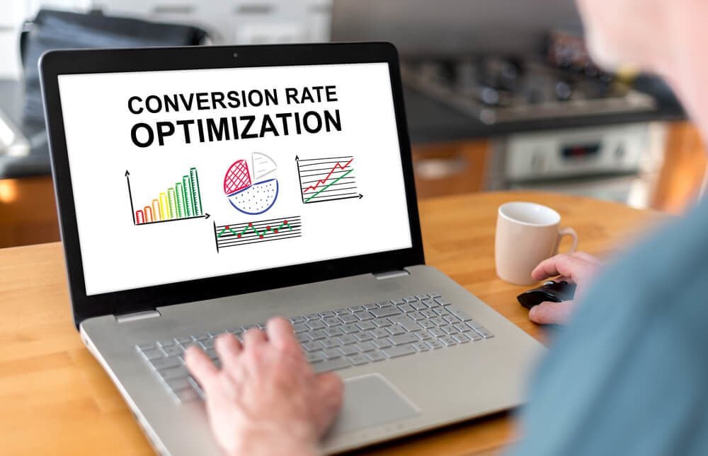 conversion rate optimization_Man using a laptop with conversion rate optimization concept on the screen