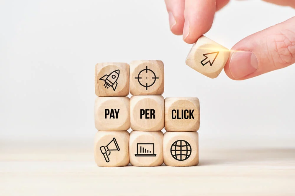 pay per click strategy_Concept Pay per click or PPC. Person stacks wooden cubes from text and icons