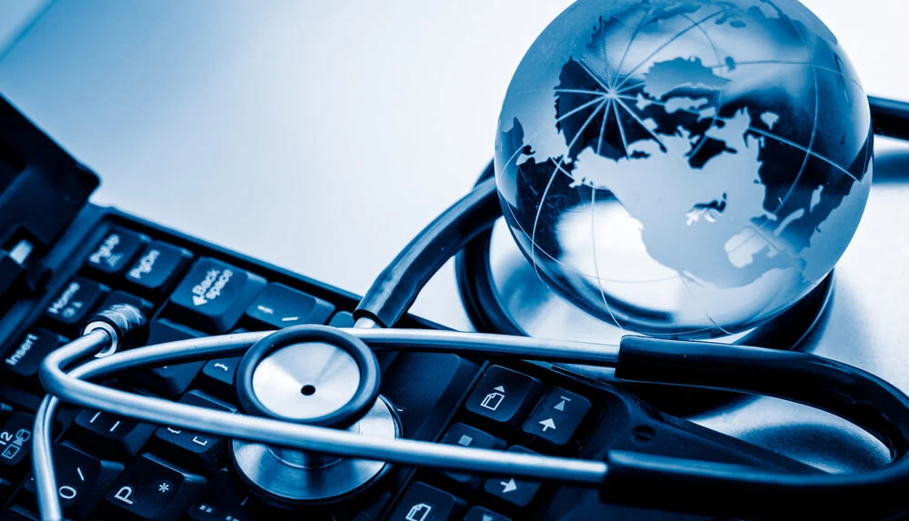 medical marketing_Glass globe and stethoscope on a computer keyboard.blue toned images.