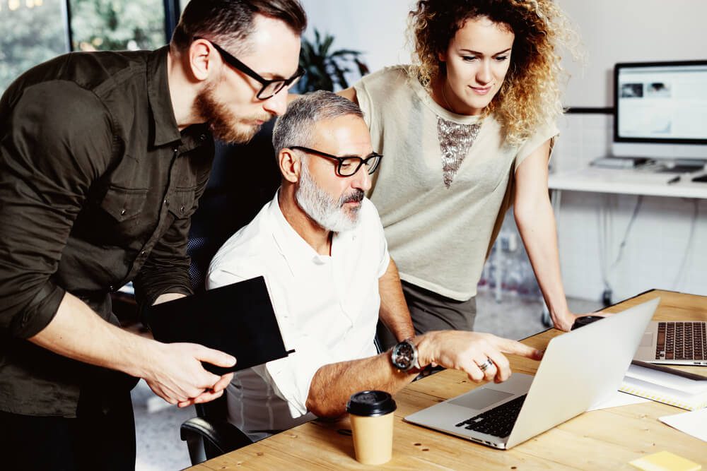 digital marketing company_Adult boss and his assistant making great brainstorming in modern office.Bearded successful businessman talking with colleague about startup project.Business people discussion concept.Vertical.