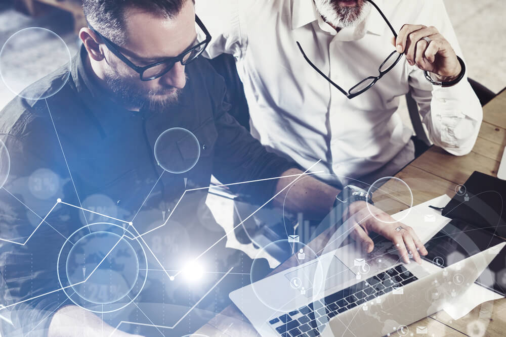 digital marketing company_Concept of digital screen,virtual connection icon,diagram, graph interfaces.Closeup view of bearded man working together with adult businessman colleague at the wooden table.Flare,blurred