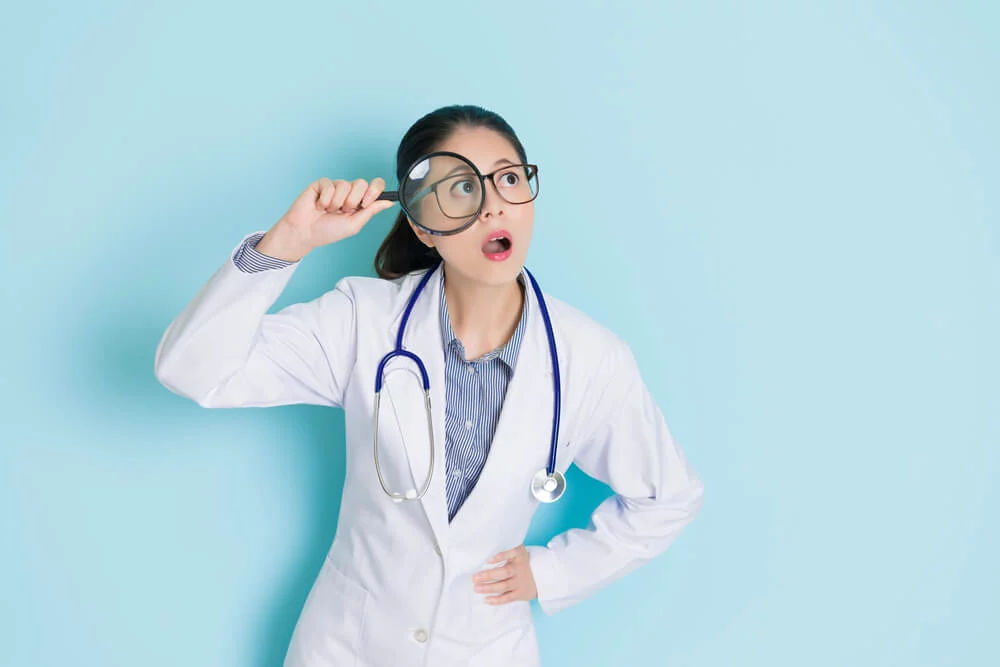 medical seo_beautiful pretty doctor woman holding magnifier tool looking at empty area daydreaming and thinking medical care idea isolated on blue background